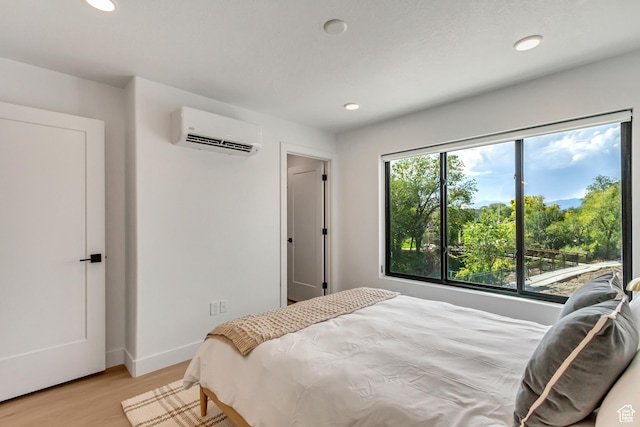 4186 S Main St Unit N220, Millcreek, UT 84107 - bedroom featuring a wall mounted AC, recessed lighting, light wood finished floors, and baseboards