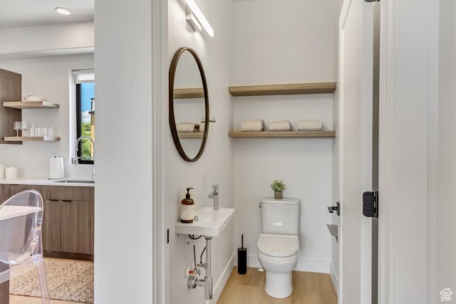 4186 S Main St Unit N220, Millcreek, UT 84107 - bathroom featuring toilet, wood finished floors, baseboards, and a sink