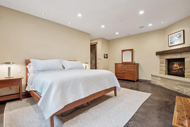 4891 Last Stand Dr, Snyderville, UT 84098 - bedroom with finished concrete flooring, recessed lighting, and a stone fireplace