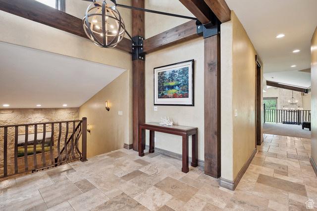 4891 Last Stand Dr, Snyderville, UT 84098 - hallway featuring stone tile floors, a chandelier, an upstairs landing, recessed lighting, and baseboards
