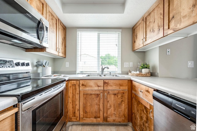 1180 W Middlesex Rd S, Taylorsville, UT 84123 - kitchen with appliances with stainless steel finishes, a sink, light countertops, brown cabinets, and a tray ceiling