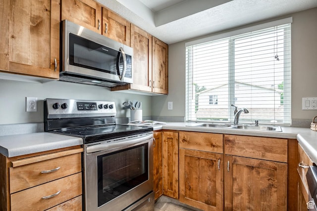 1180 W Middlesex Rd S, Taylorsville, UT 84123 - kitchen featuring stainless steel appliances, a sink, brown cabinets, and light countertops