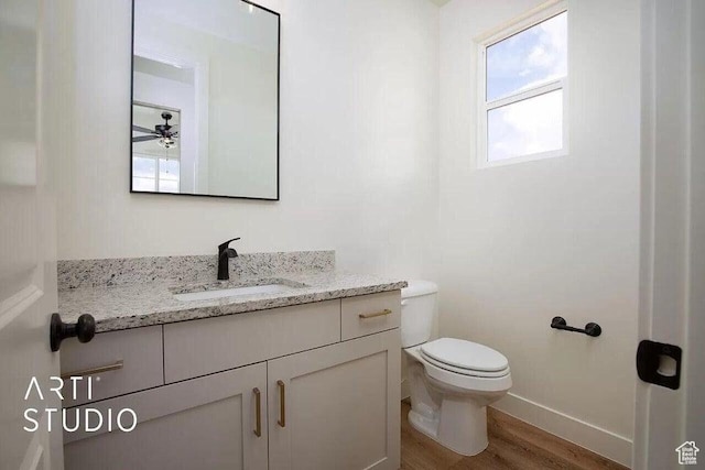 4883 N 10 E, Enoch, UT 84721 - half bathroom featuring wood finished floors, toilet, vanity, baseboards, and a ceiling fan