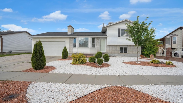 2976 S Laree St, West Valley City, UT 84120 - tri-level home with a garage, a chimney, and driveway