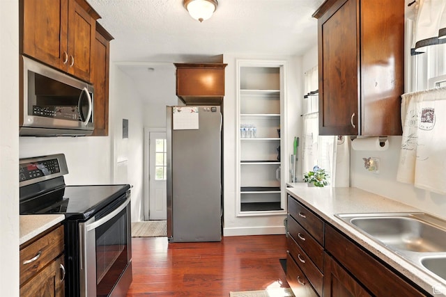 575 5th St, Ogden, UT 84404 - kitchen with appliances with stainless steel finishes, a sink, dark wood-type flooring, and light countertops