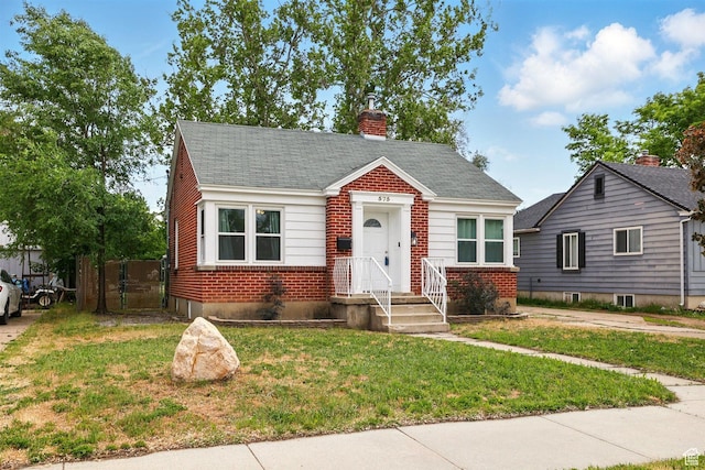 575 5th St, Ogden, UT 84404 - bungalow featuring brick siding, a front yard, a chimney, and roof with shingles