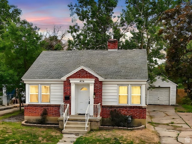 575 5th St, Ogden, UT 84404 - view of front of property with brick siding, driveway, a chimney, a garage, and a shingled roof