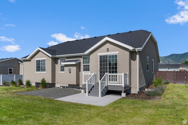 5667 N Parkview Dr, Stansbury Park, UT 84074 - back of house with a patio area, stucco siding, a deck with mountain view, and a shingled roof
