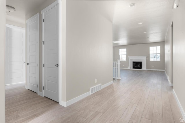 hall with light wood-type flooring, baseboards, and recessed lighting