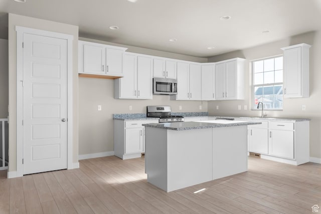 kitchen with stainless steel appliances, light wood-type flooring, white cabinets, baseboards, and recessed lighting