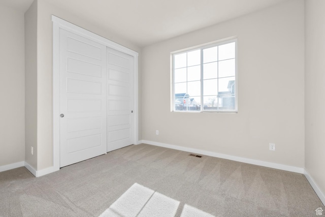 unfurnished bedroom with carpet floors, baseboards, and a closet