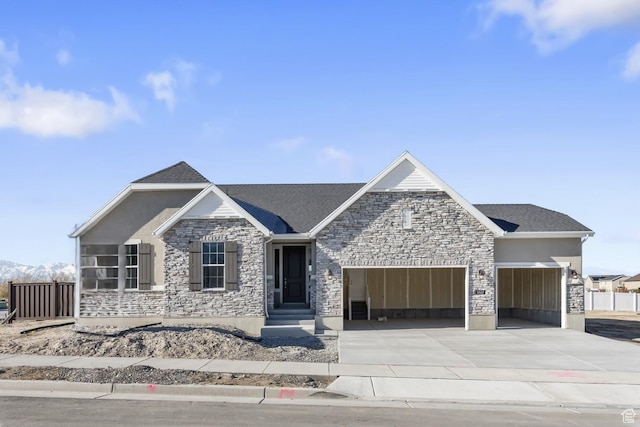 view of front of home featuring stone siding, an attached garage, concrete driveway, and stucco siding