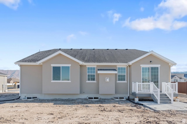 back of property with roof with shingles and stucco siding