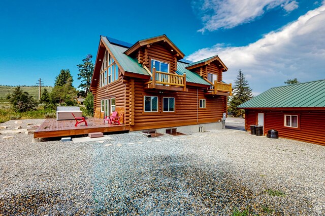 450 Crestview Dr, Summit Park, UT 84098 - back of property with log exterior, a balcony, metal roof, a deck, and roof mounted solar panels