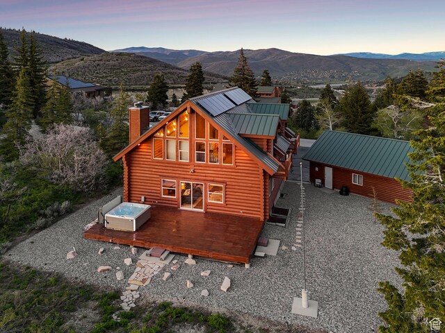 450 Crestview Dr, Summit Park, UT 84098 - back of house at dusk with a chimney, log siding, a deck with mountain view, metal roof, and a standing seam roof