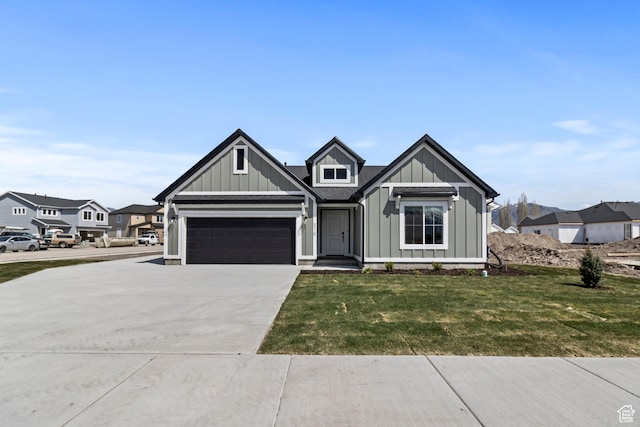 516 S 1580 W Unit 130, Logan, UT 84321 - view of front of home with board and batten siding, concrete driveway, and a front lawn