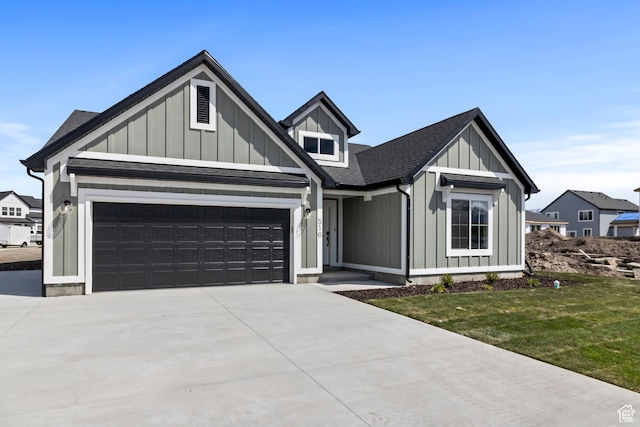 516 S 1580 W Unit 130, Logan, UT 84321 - view of front facade with an attached garage, board and batten siding, driveway, and roof with shingles