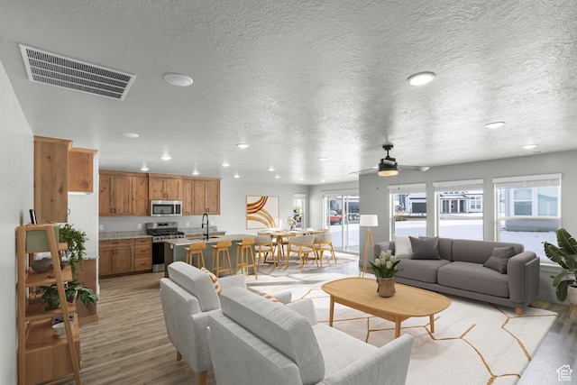 516 S 1580 W Unit 130, Logan, UT 84321 - living area featuring light wood-style floors, recessed lighting, ceiling fan, and a textured ceiling