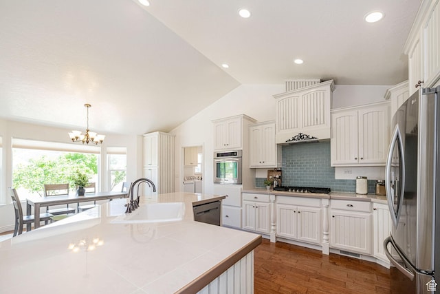 522 W 700 S, Springville, UT 84663 - kitchen featuring stainless steel appliances, a sink, independent washer and dryer, vaulted ceiling, and a chandelier