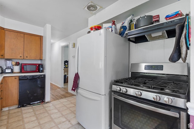3466 W 4305 S, West Valley City, UT 84119 - kitchen with black dishwasher, gas stove, light floors, freestanding refrigerator, and brown cabinetry