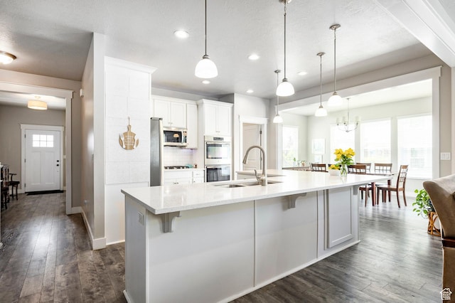10352 S Sturgeon Dr W, South Jordan, UT 84009 - kitchen featuring a sink, appliances with stainless steel finishes, dark wood-style flooring, a kitchen bar, and white cabinetry