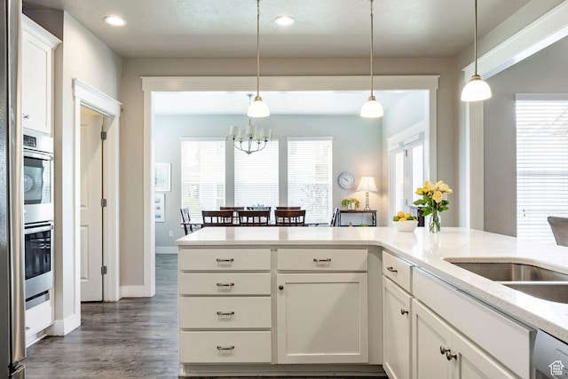 10352 S Sturgeon Dr W, South Jordan, UT 84009 - kitchen featuring a chandelier, hanging light fixtures, dark wood-style flooring, white cabinets, and recessed lighting