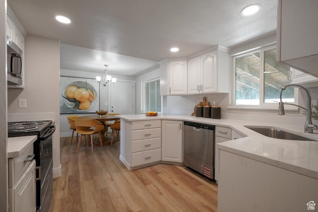 2612 S 8590 W, Magna, UT 84044 - kitchen featuring stainless steel appliances, a sink, white cabinetry, light wood finished floors, and a peninsula