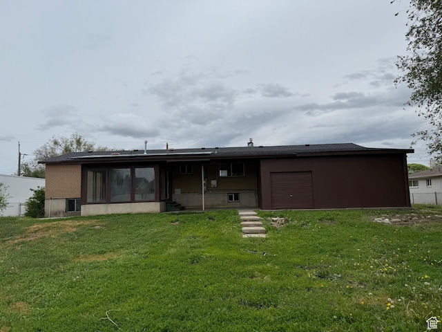 2612 S 8590 W, Magna, UT 84044 - back of house featuring an attached garage, a lawn, and a sunroom