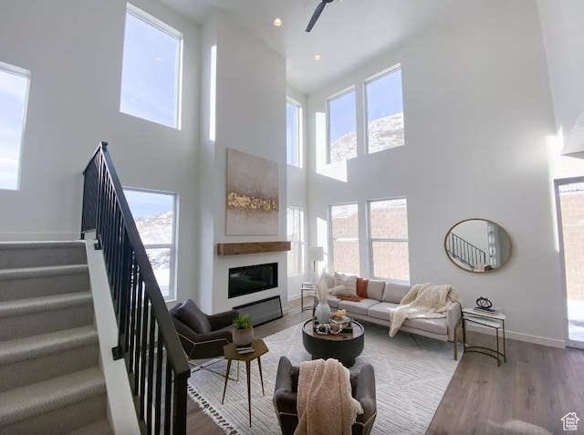5894 N Canyon Rim Rd E Unit 621, Lehi, UT 84043 - living area with a towering ceiling, stairs, wood finished floors, baseboards, and a glass covered fireplace