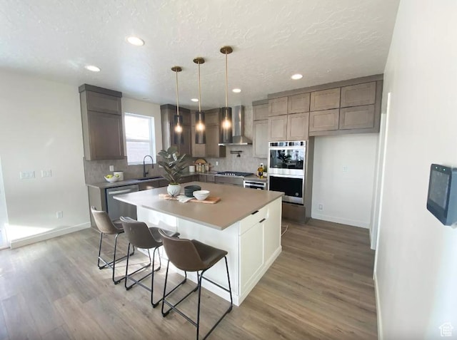 5894 N Canyon Rim Rd E Unit 621, Lehi, UT 84043 - kitchen featuring a sink, wall chimney range hood, stainless steel appliances, tasteful backsplash, and recessed lighting