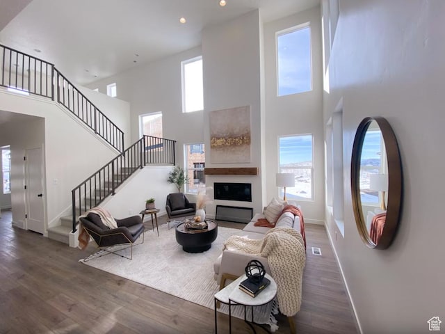 5894 N Canyon Rim Rd E Unit 621, Lehi, UT 84043 - living area featuring stairs, baseboards, a towering ceiling, wood finished floors, and a glass covered fireplace