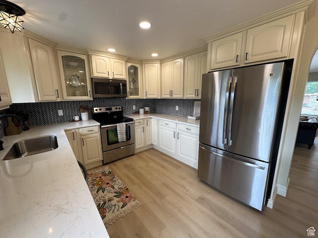 1391 E Mccormick Way, Cottonwood Heights, UT 84121 - kitchen with appliances with stainless steel finishes, a sink, light wood-type flooring, tasteful backsplash, and recessed lighting