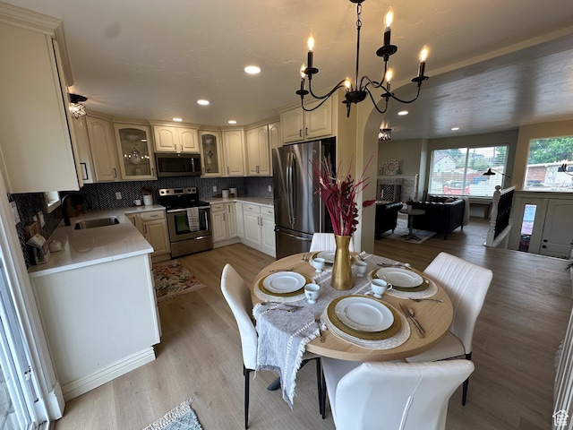 1391 E Mccormick Way, Cottonwood Heights, UT 84121 - dining space with light wood-style flooring, a chandelier, a fireplace, and recessed lighting