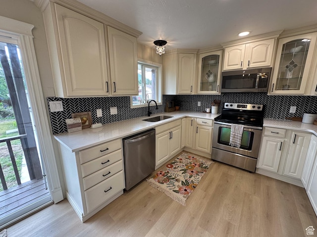 1391 E Mccormick Way, Cottonwood Heights, UT 84121 - kitchen featuring stainless steel appliances, a sink, light wood finished floors, and decorative backsplash