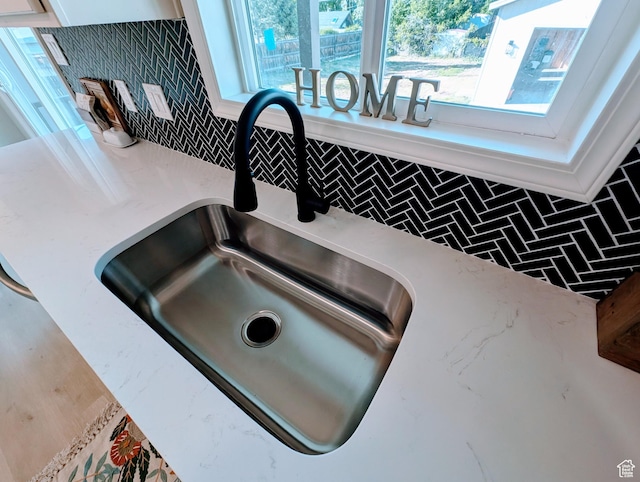 1391 E Mccormick Way, Cottonwood Heights, UT 84121 - kitchen view of a sink, decorative backsplash, and white cabinetry