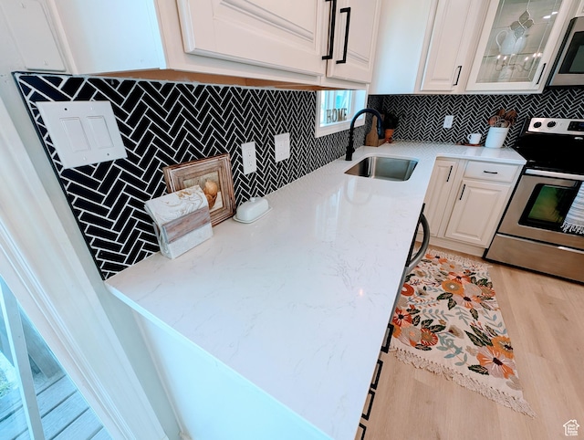 1391 E Mccormick Way, Cottonwood Heights, UT 84121 - kitchen featuring a sink, stainless steel appliances, white cabinetry, backsplash, and glass insert cabinets
