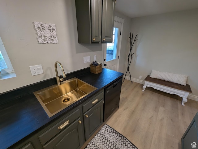 1391 E Mccormick Way, Cottonwood Heights, UT 84121 - kitchen with black dishwasher, a sink, dark countertops, light wood-style flooring, and baseboards