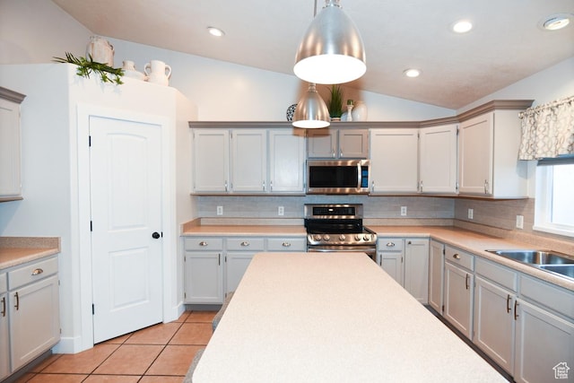 3155 S Autumn Blaze Cv W, West Valley City, UT 84128 - kitchen featuring appliances with stainless steel finishes, light tile patterned floors, decorative backsplash, light countertops, and vaulted ceiling
