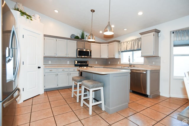 3155 S Autumn Blaze Cv W, West Valley City, UT 84128 - kitchen with appliances with stainless steel finishes, a sink, tasteful backsplash, a center island, and light tile patterned floors