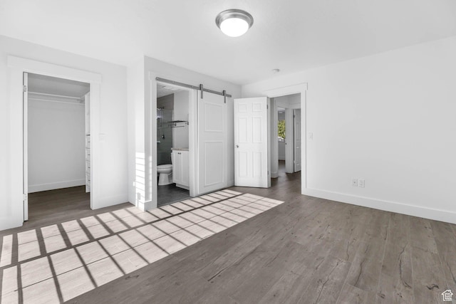 1298 S 500 E, Kaysville, UT 84037 - unfurnished bedroom with baseboards, wood finished floors, a spacious closet, a closet, and a barn door