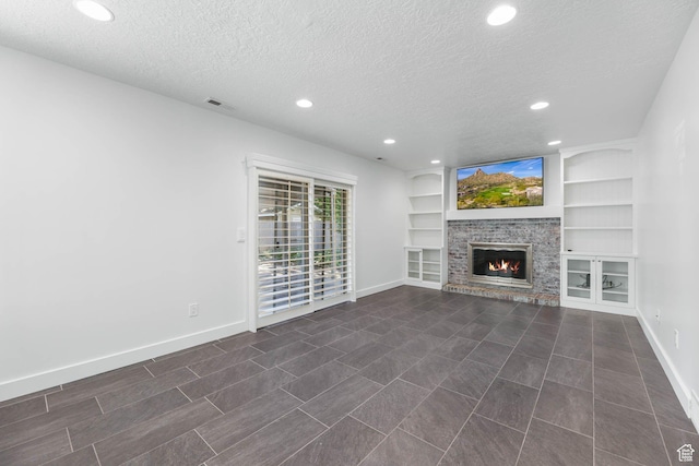 1298 S 500 E, Kaysville, UT 84037 - unfurnished living room featuring baseboards, a textured ceiling, recessed lighting, a glass covered fireplace, and built in features