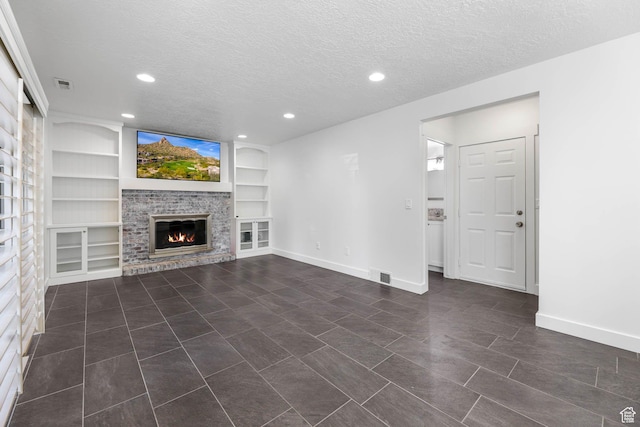 1298 S 500 E, Kaysville, UT 84037 - unfurnished living room with a glass covered fireplace, a textured ceiling, built in shelves, baseboards, and recessed lighting