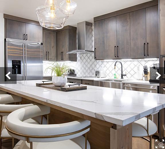 3000 Canyons Resort Dr Unit 10-602, Park City, UT 84098 - kitchen featuring wall chimney exhaust hood, appliances with stainless steel finishes, a sink, and dark brown cabinets