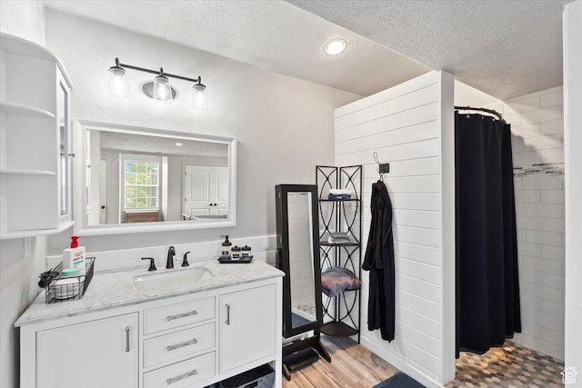 2899 W 8870 S, West Jordan, UT 84088 - bathroom featuring a textured ceiling, a tile shower, vanity, and wood finished floors