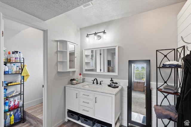2899 W 8870 S, West Jordan, UT 84088 - bathroom featuring a textured ceiling, wood finished floors, vanity, and baseboards