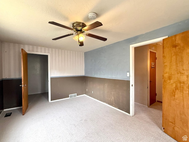 carpeted empty room with ceiling fan, a smoke detector, and baseboards
