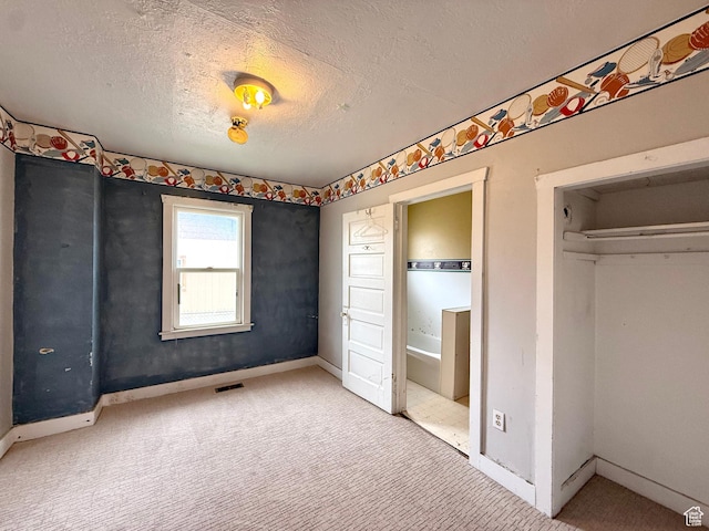 unfurnished bedroom featuring carpet flooring, a textured ceiling, and baseboards