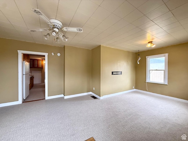 spare room featuring carpet flooring, ceiling fan, and baseboards