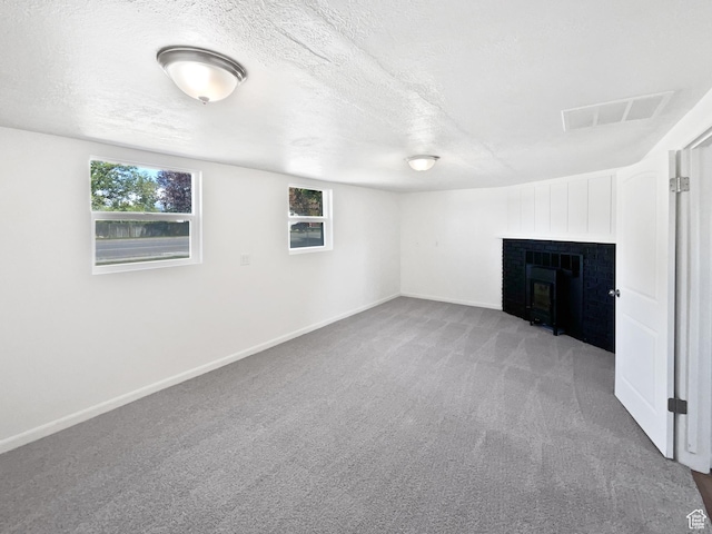 2959 W 1300 N, Clinton, UT 84015 - basement featuring carpet floors, a fireplace, plenty of natural light, a textured ceiling, and baseboards