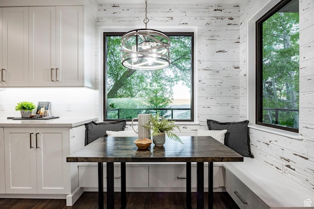 dining area with breakfast area, a chandelier, healthy amount of natural light, and dark wood finished floors